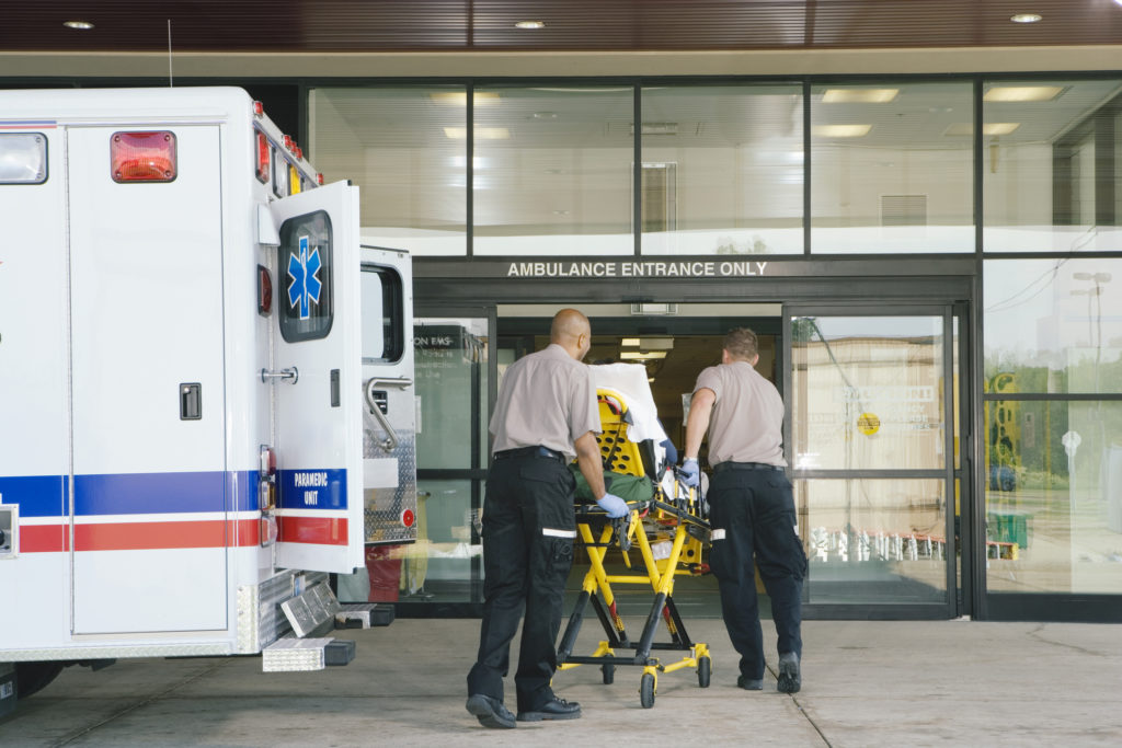 paramedics taking patient from ambulance to hospital