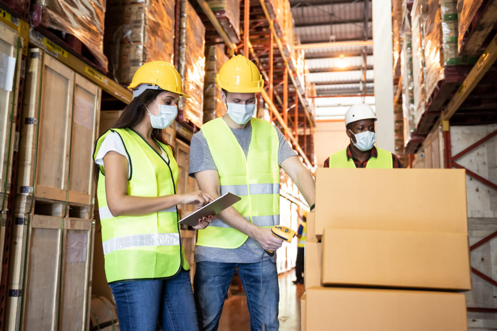 warehouse workers taking inventory while wearing masks