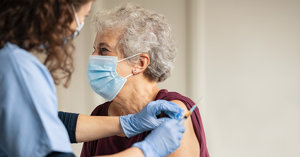 elderly woman getting vaccination from healthcare worker