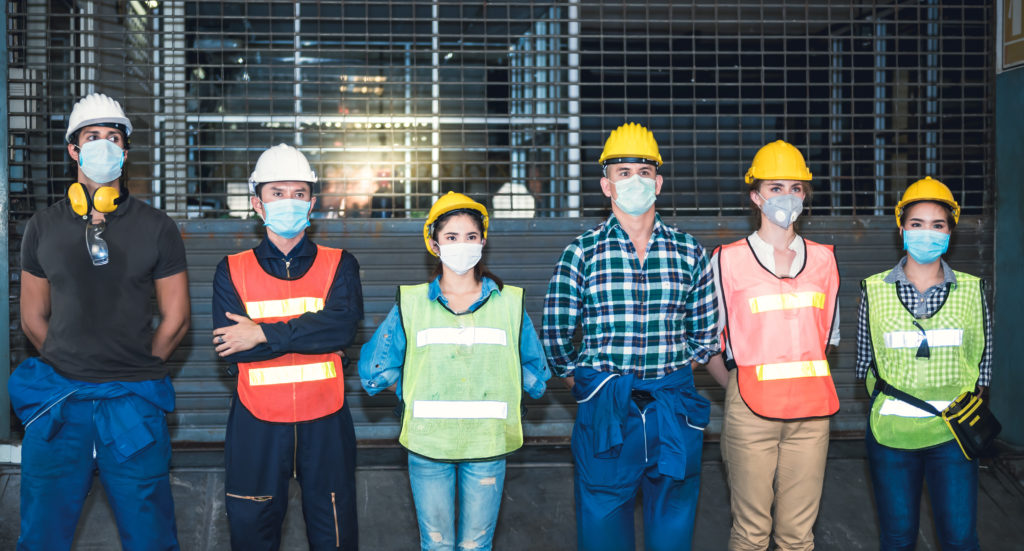 Group of workers standing in a line wearing masks