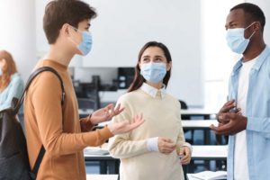 3 students talking in classroom wearing face masks