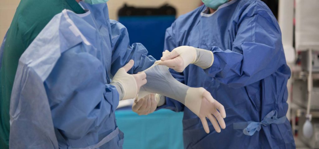healthcare workers putting on latex gloves