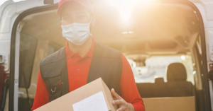 man wearing mask delivering resources from a van