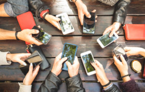 people using their phones around a table