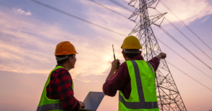2 electric utilities workers communicating with radios